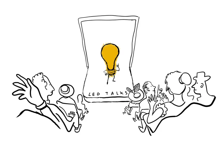 The lightbulb character on stage giving an “LED Talks” presentation to an excited audience